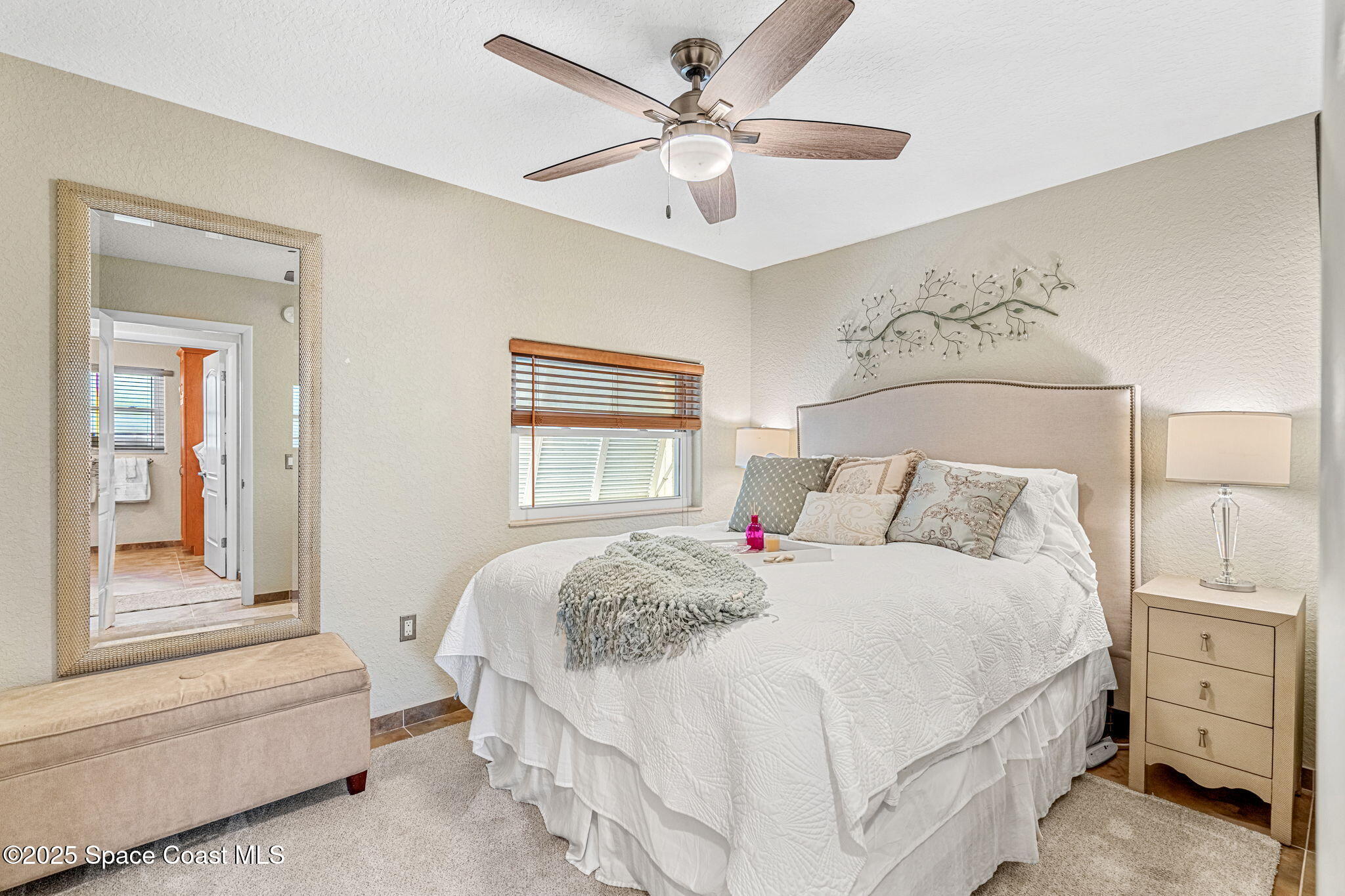 561 Capri Road Cocoa Beach, FL 32931 - Photo 53 of 82 a bedroom with a bed and a chandelier fan