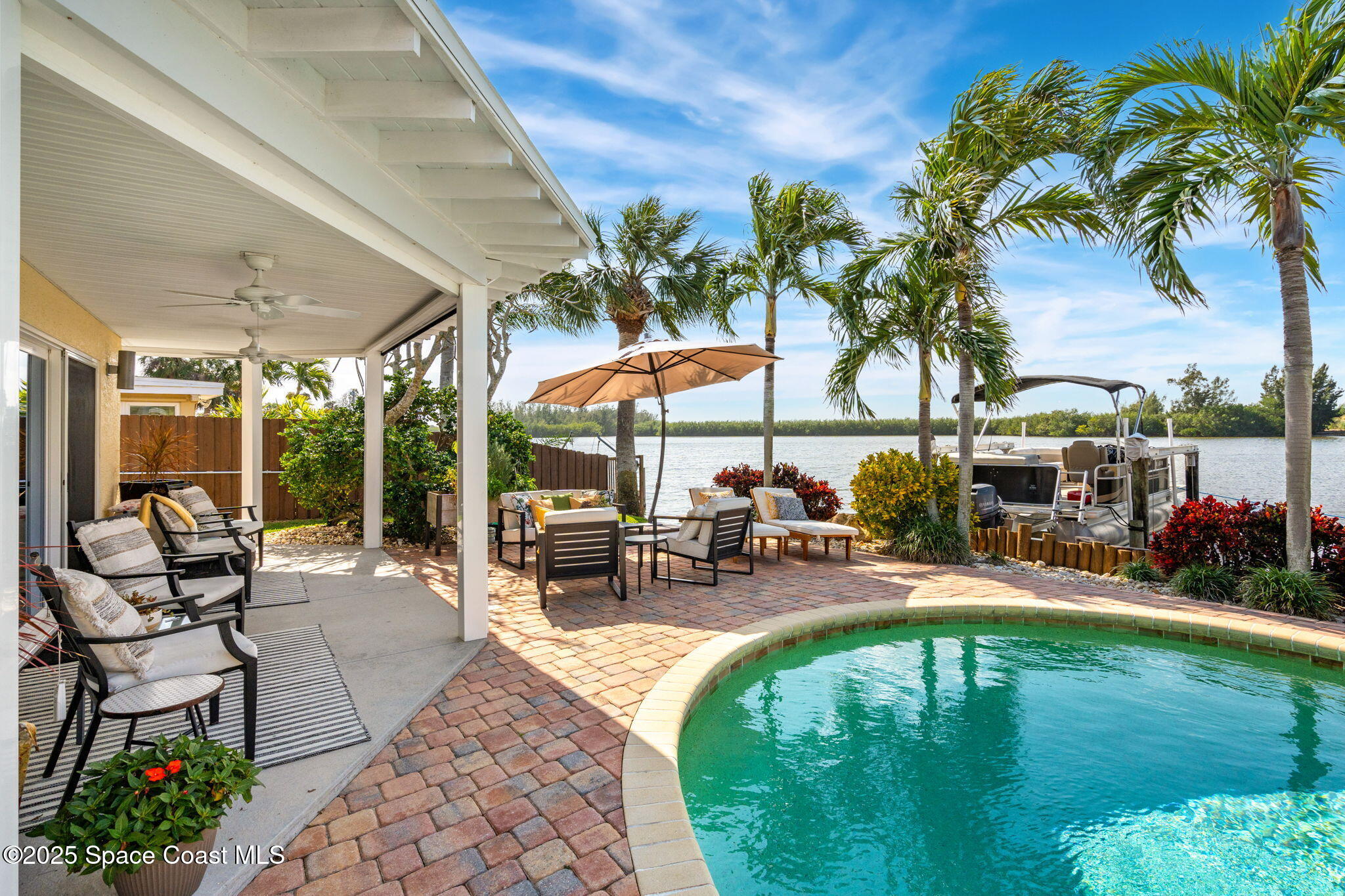 561 Capri Road Cocoa Beach, FL 32931 - Photo 56 of 82 a view of a swimming pool with chairs in patio