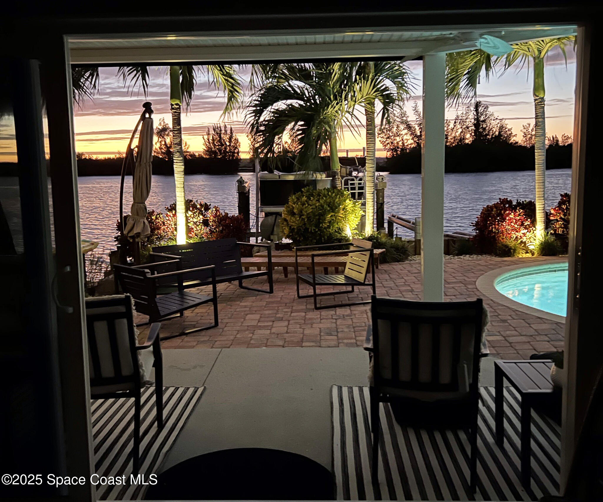 561 Capri Road Cocoa Beach, FL 32931 - Photo 78 of 82 a living room with fireplace furniture and a floor to ceiling window