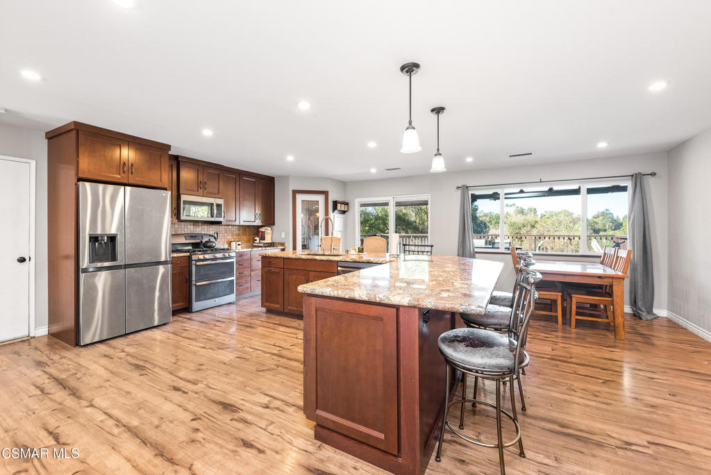 683 Languid Lane Simi Valley, CA 93065 - Photo 6 of 27 a kitchen with stainless steel appliances kitchen island granite countertop a table chairs and a kitchen view