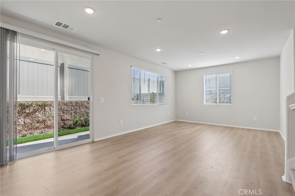 1110 Tropic Court Redlands, CA 92374 - Photo 11 of 44 an empty room with wooden floor and windows