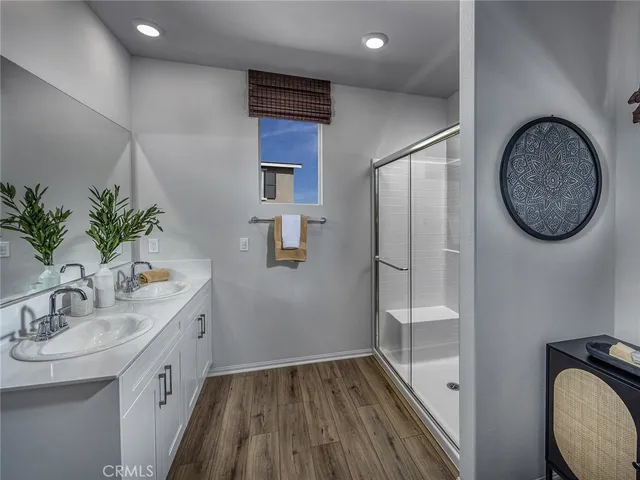 a bathroom with a sink a mirror and a potted plant