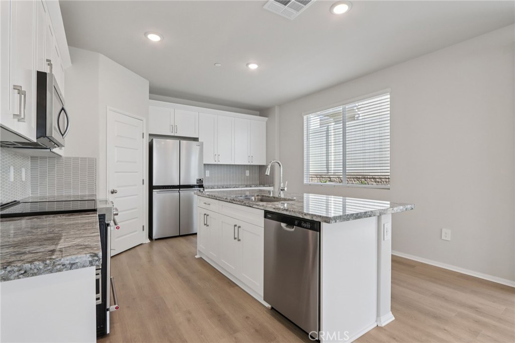 1110 Tropic Court Redlands, CA 92374 - Photo 12 of 44 a kitchen with granite countertop a sink stove and refrigerator