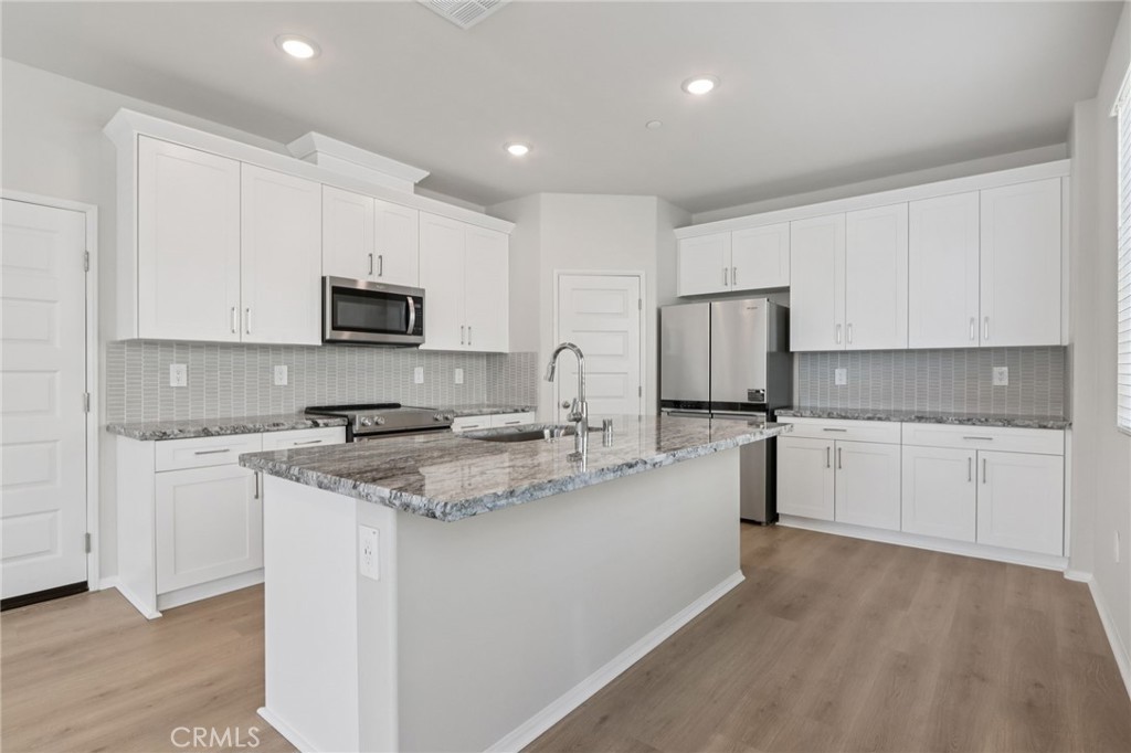 1110 Tropic Court Redlands, CA 92374 - Photo 13 of 44 a kitchen with stainless steel appliances granite countertop a sink stove refrigerator and cabinets