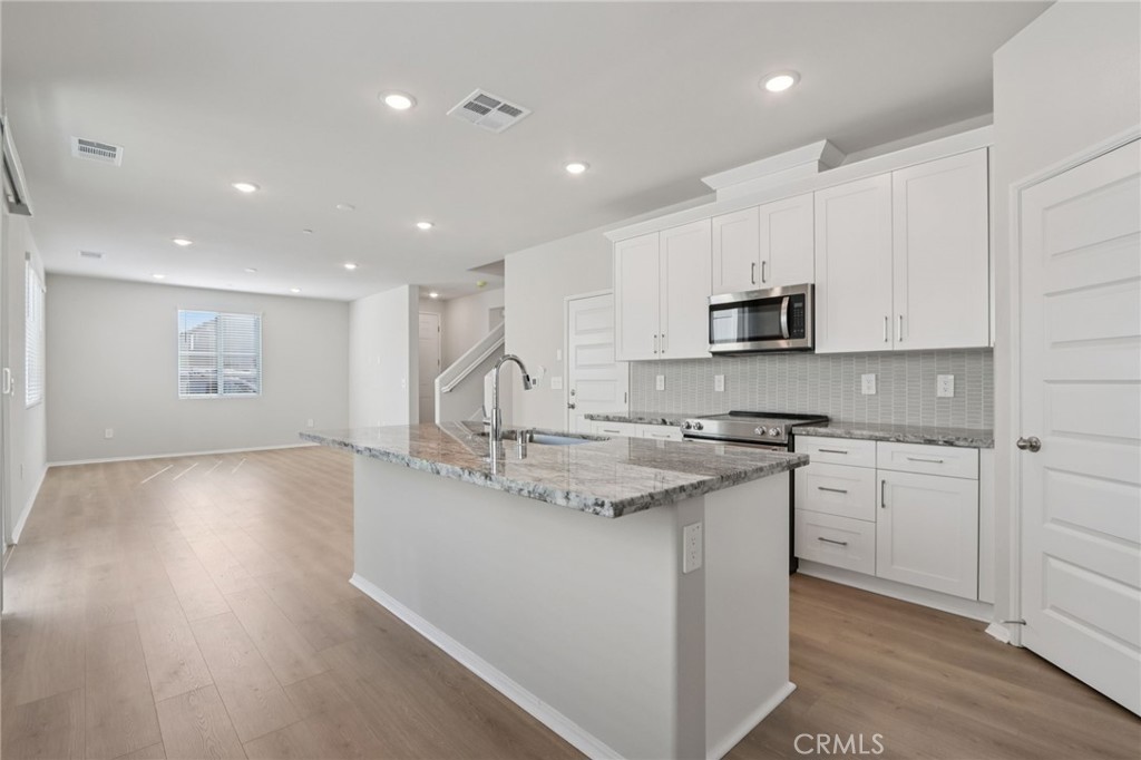 1110 Tropic Court Redlands, CA 92374 - Photo 14 of 44 a kitchen with kitchen island a sink appliances cabinets and a counter top space