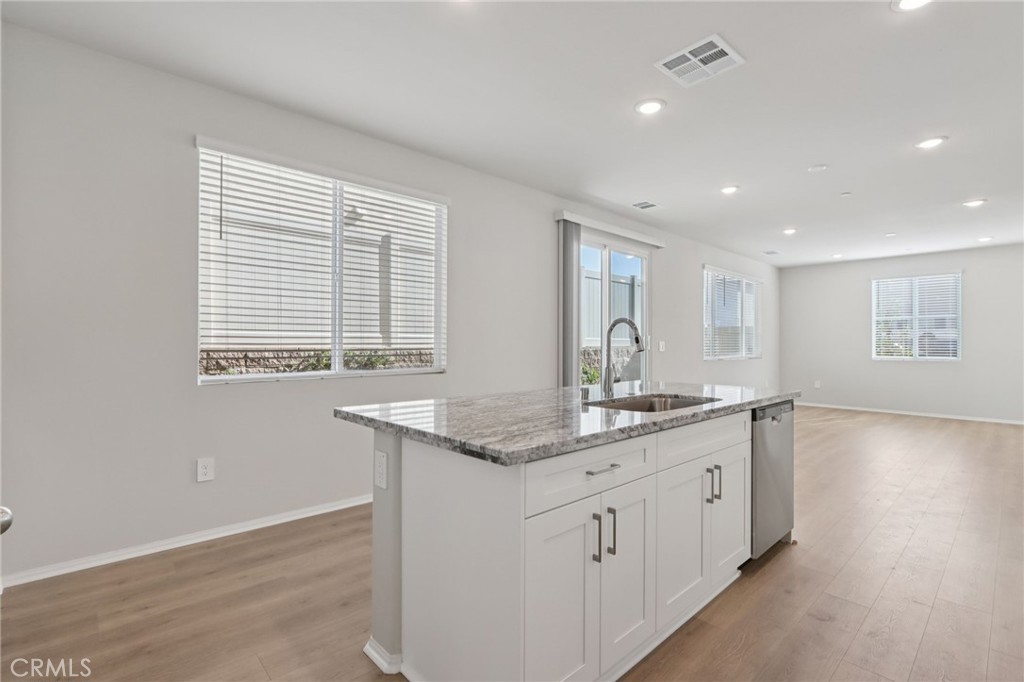 1110 Tropic Court Redlands, CA 92374 - Photo 15 of 44 a hall with kitchen island a sink dishwasher and a large mirror with wooden floor