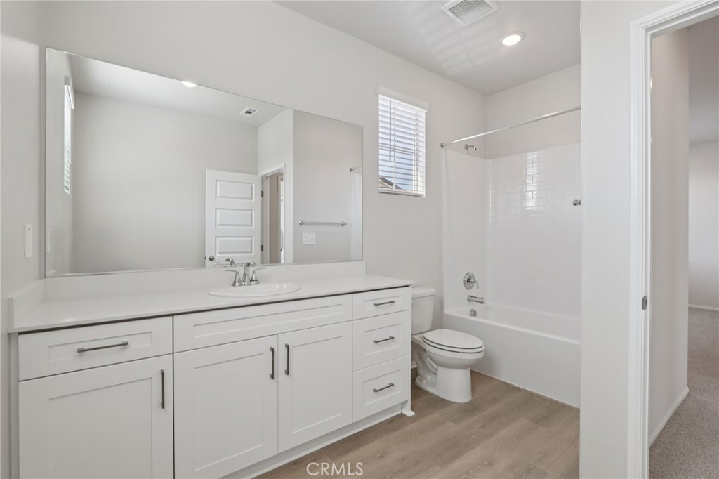 1110 Tropic Court Redlands, CA 92374 - Photo 26 of 44 a bathroom with a granite countertop sink a toilet and a mirror