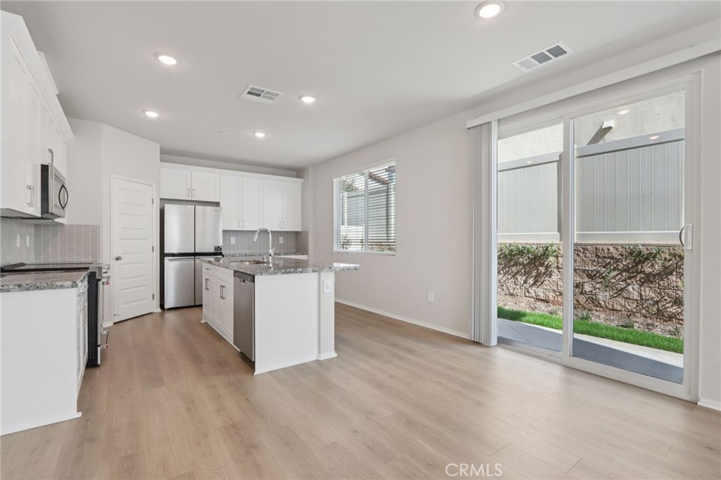 1110 Tropic Court Redlands, CA 92374 - Photo 9 of 44 a open kitchen with white cabinets and wooden floor