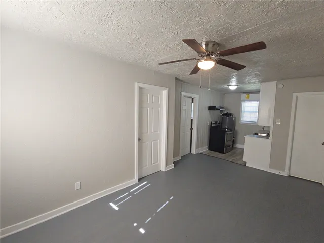 an empty room with closet and a ceiling fan