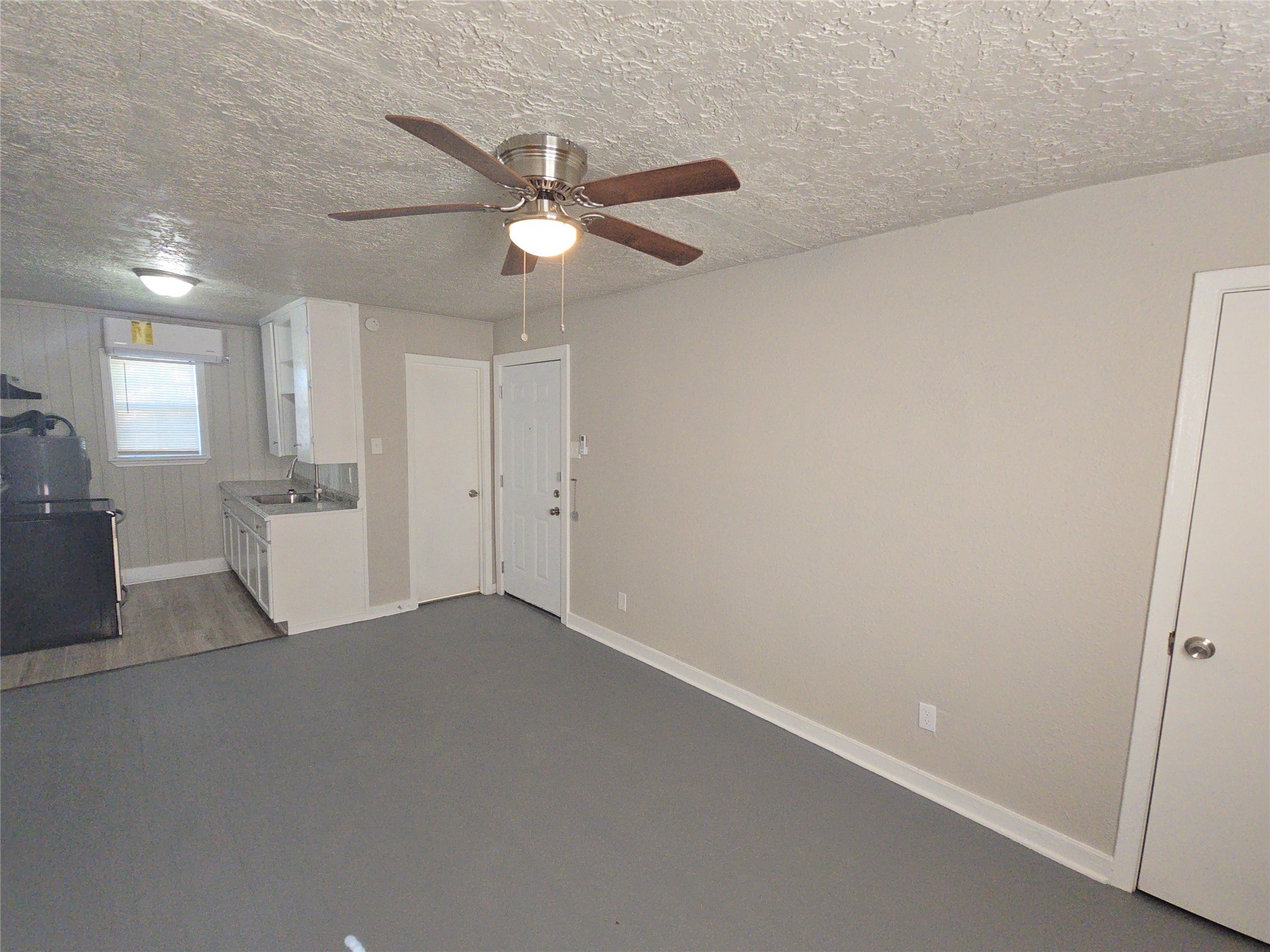 3335 Tuam Street, Unit 2 Houston, TX 77004 - Photo 3 of 15 an empty room with a kitchen and a ceiling fan