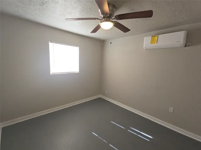 an empty room with a window and a fan