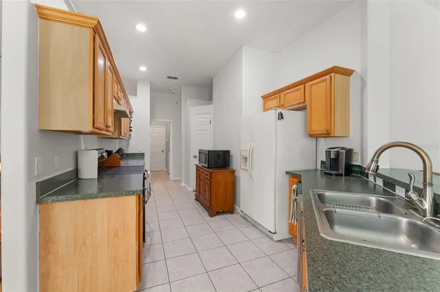 a kitchen with stainless steel appliances granite countertop a sink a stove and refrigerator