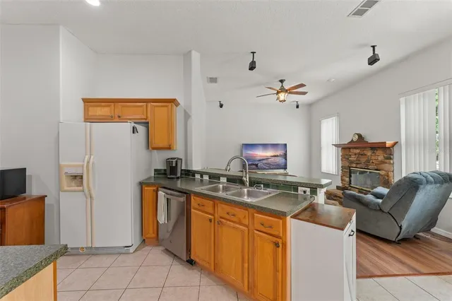 a kitchen with stainless steel appliances granite countertop a sink and a refrigerator