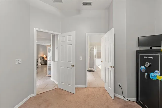 a view of a hallway with wooden floor and a living room