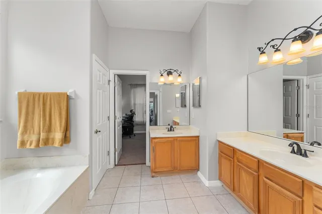 a spacious bathroom with a tub sink and mirror