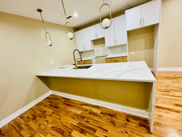 a kitchen with stainless steel appliances granite countertop a sink a stove and a wooden floors