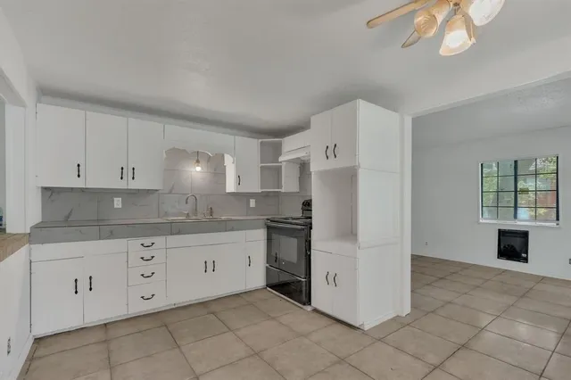 a kitchen with white cabinets and appliances