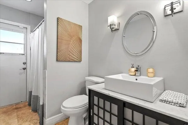a bathroom with a sink toilet and a mirror