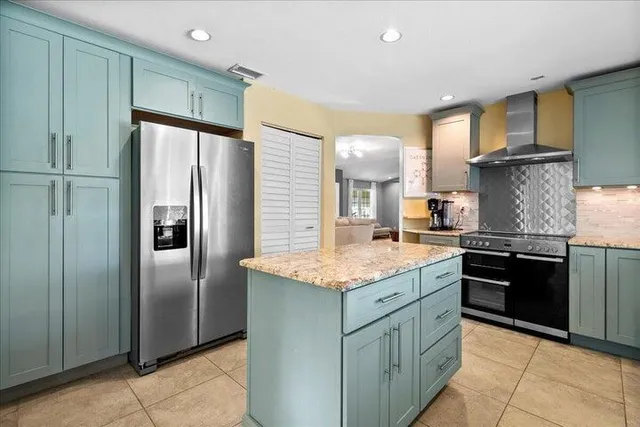 a kitchen with stainless steel appliances granite countertop a refrigerator a sink and a stove