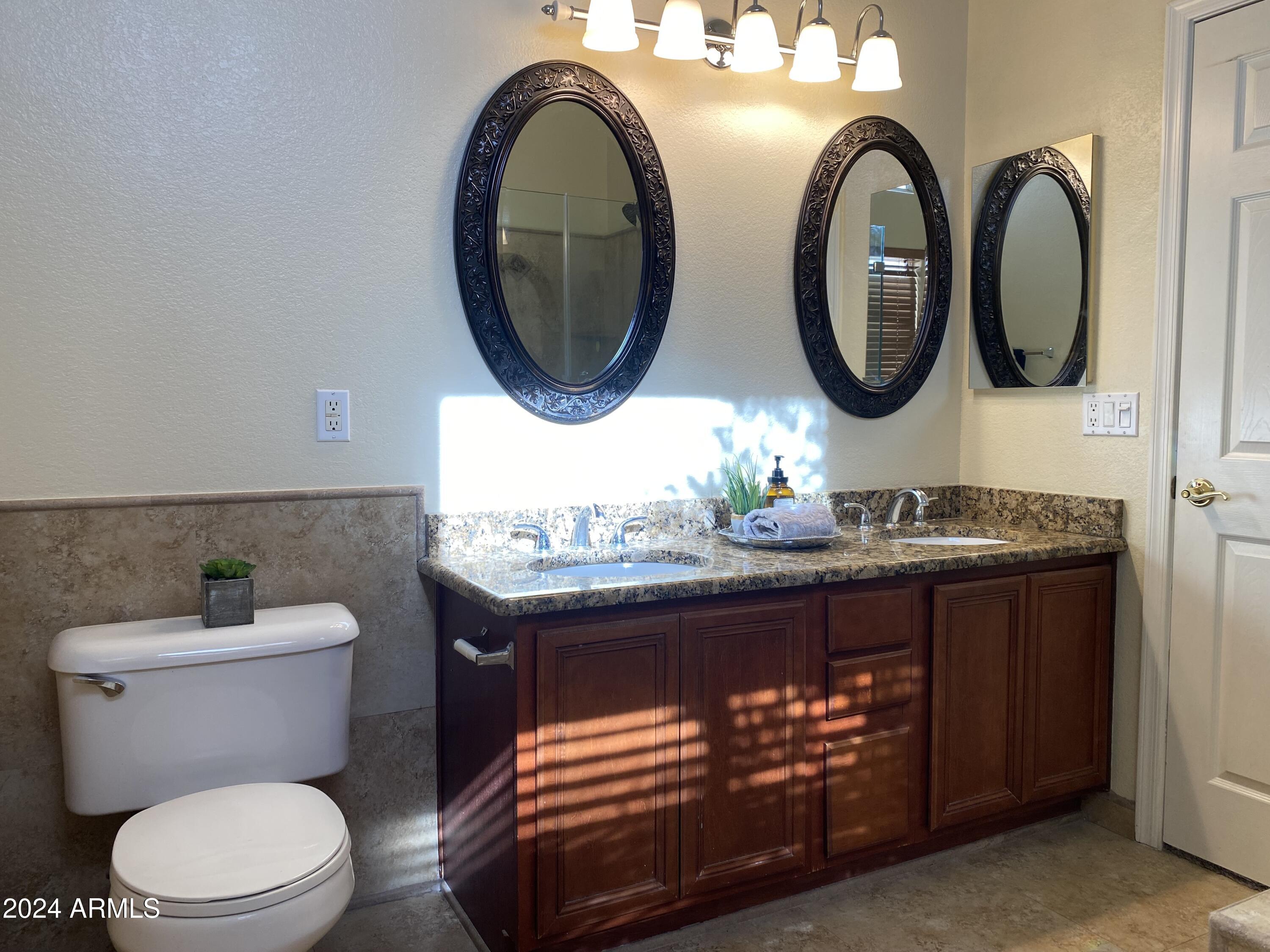 8143 West Marco Polo Road Peoria, AZ 85382 - Photo 16 of 29 a bathroom with a toilet a sink and a mirror