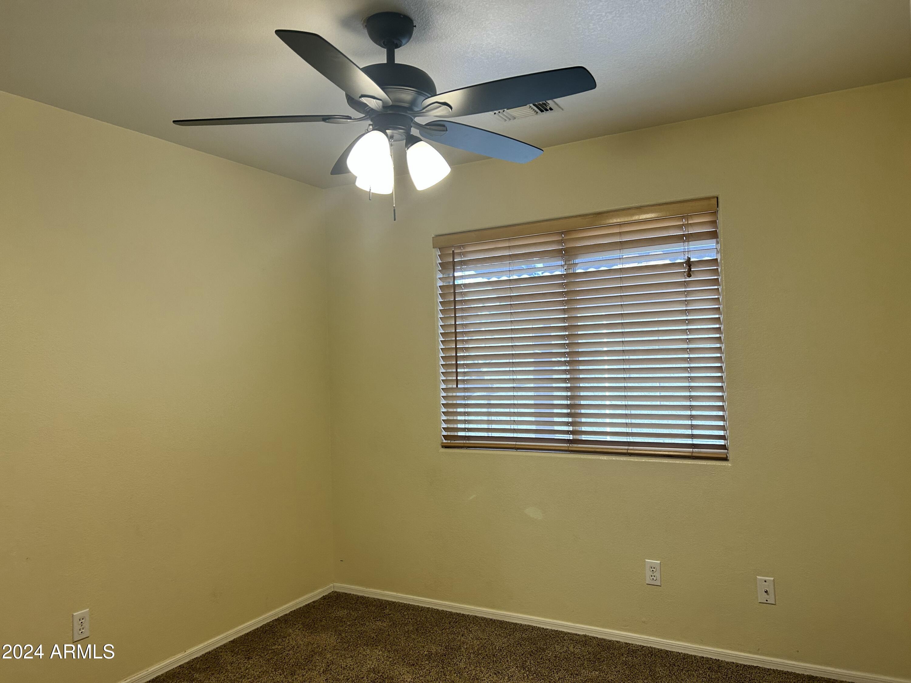 8143 West Marco Polo Road Peoria, AZ 85382 - Photo 20 of 29 an empty room with a window and a fan