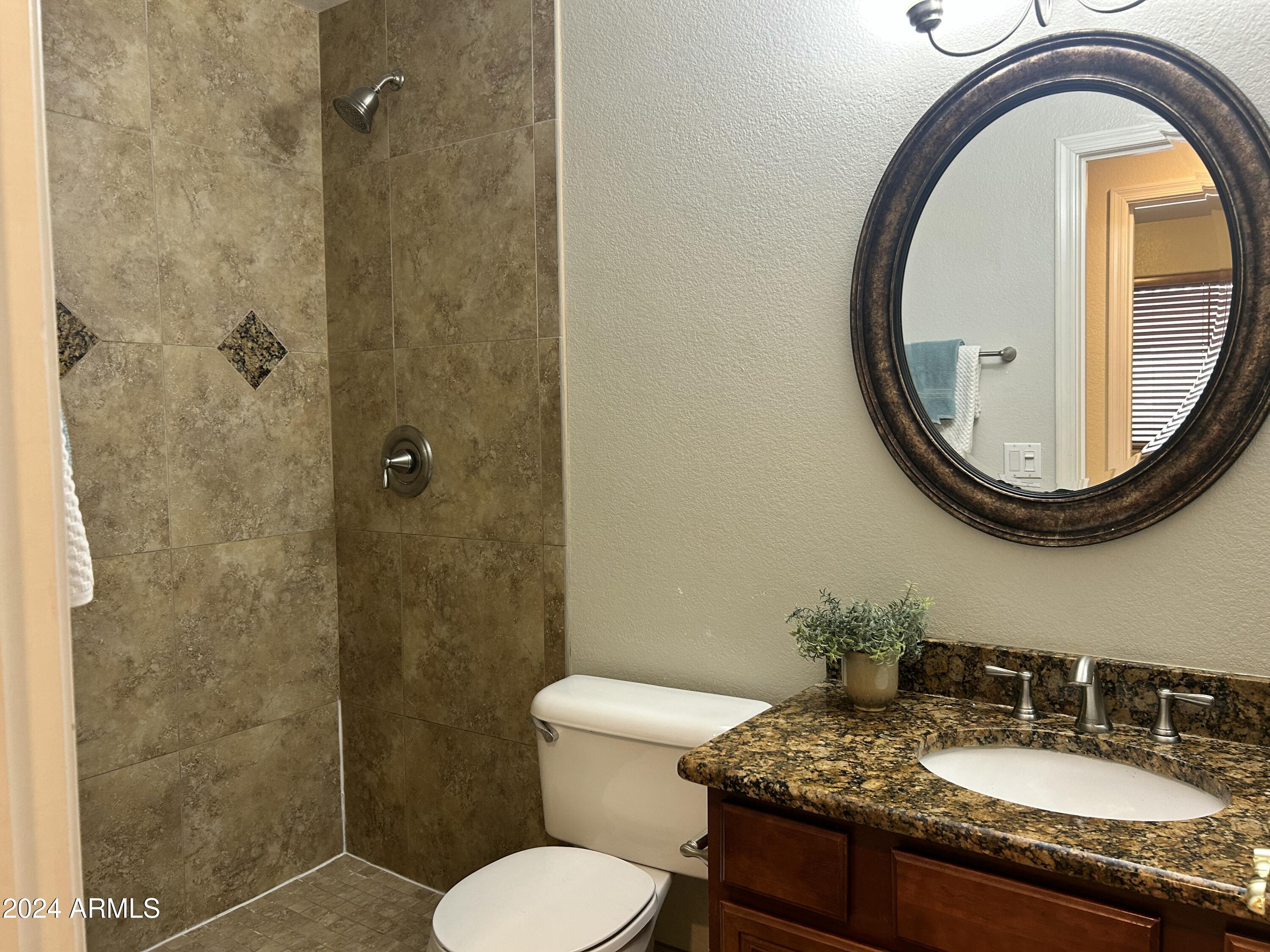 8143 West Marco Polo Road Peoria, AZ 85382 - Photo 23 of 29 a bathroom with a granite countertop toilet sink and mirror