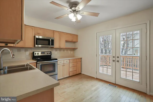 a kitchen with stainless steel appliances granite countertop a stove a sink dishwasher and a microwave oven on the kitchen countertops