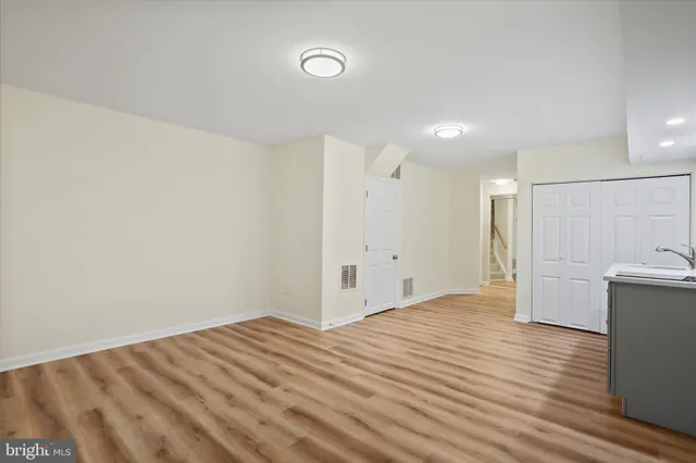 a view of empty room with wooden floor