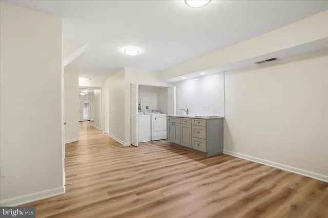 a view of a kitchen with wooden floor and a sink