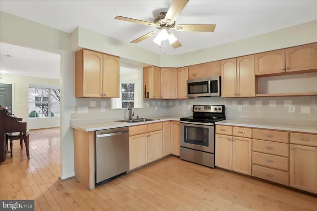 a kitchen with granite countertop a stove top oven a sink dishwasher a dining table and chairs with wooden floor