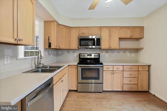 a kitchen with stainless steel appliances granite countertop a sink and a stove