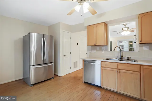 a kitchen with stainless steel appliances granite countertop a refrigerator a sink and a stove
