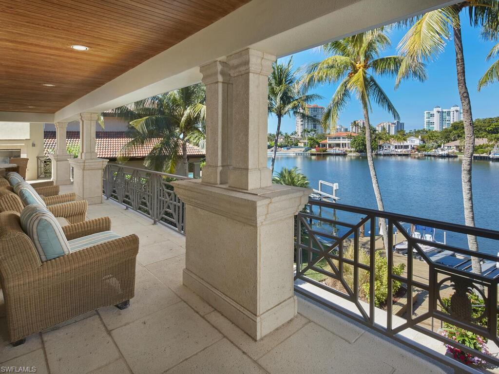377 Pirates Bight Naples, FL 34103 - Photo 34 of 44 a living room with furniture and a floor to ceiling window