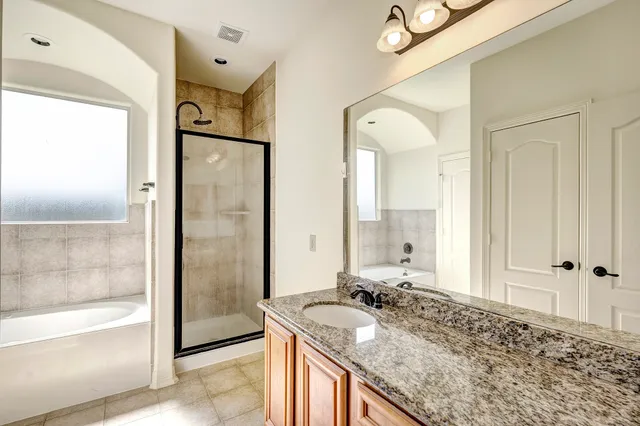 a bathroom with a granite countertop sink mirror and shower
