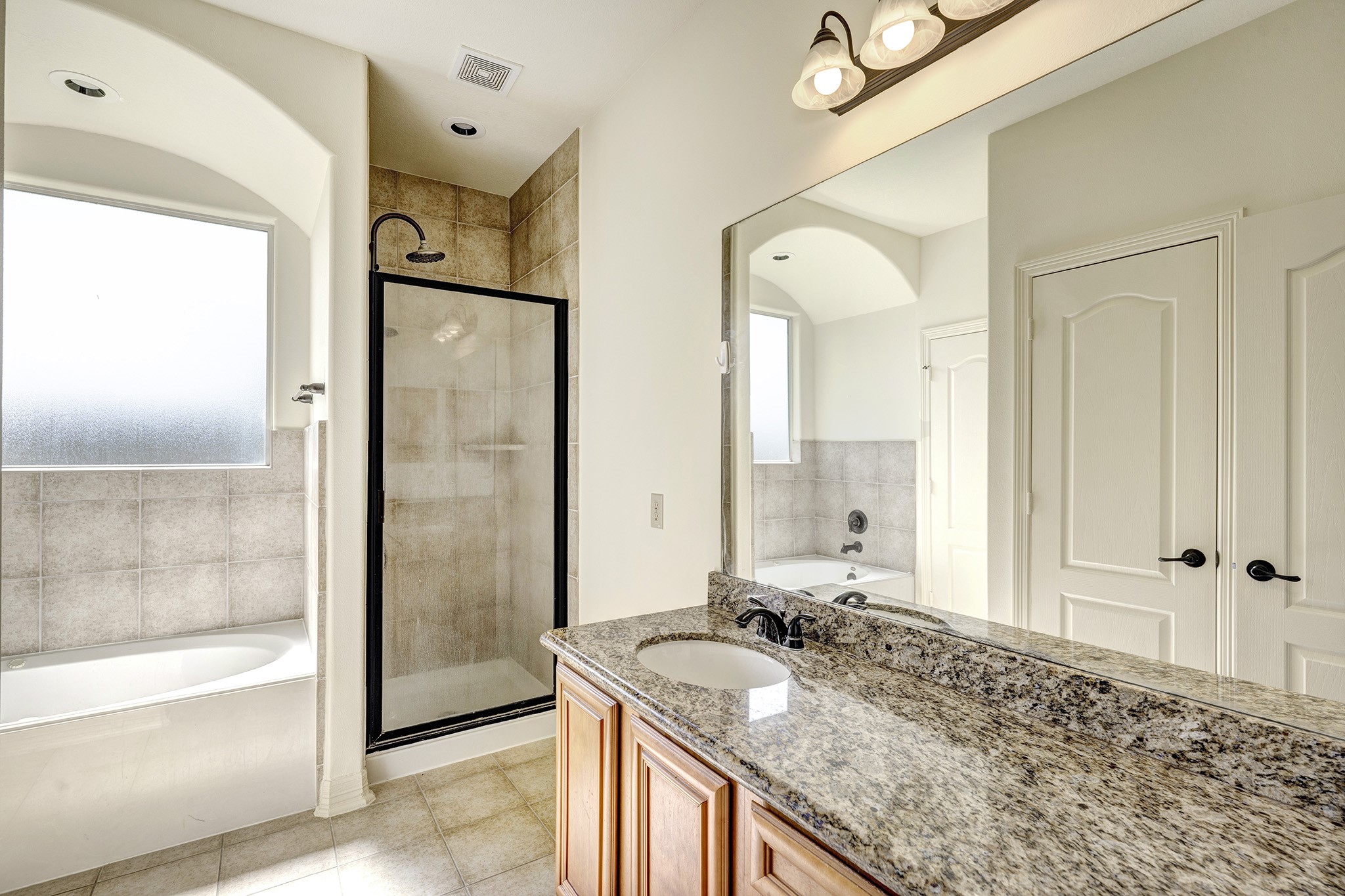 10348 Stone Gate Drive Conroe, TX 77385 - Photo 12 of 20 a bathroom with a granite countertop sink mirror and shower