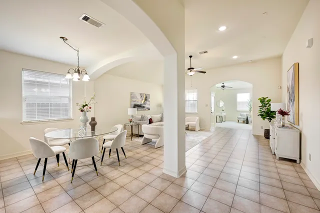 a view of a a dining room and livingroom with furniture wooden floor a chandelier