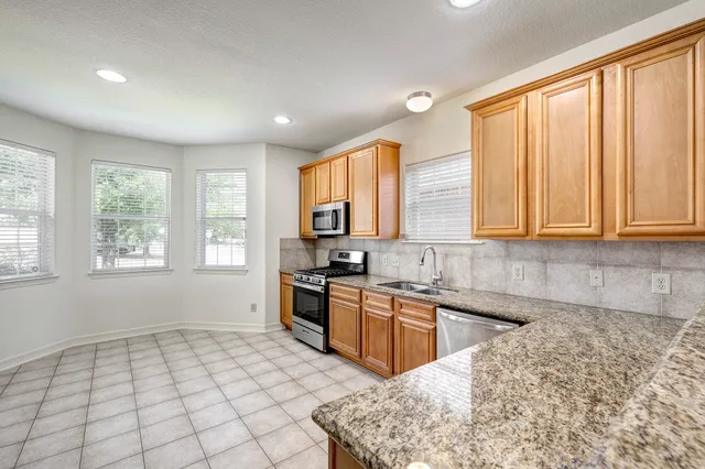 a kitchen with stainless steel appliances granite countertop a sink and cabinets