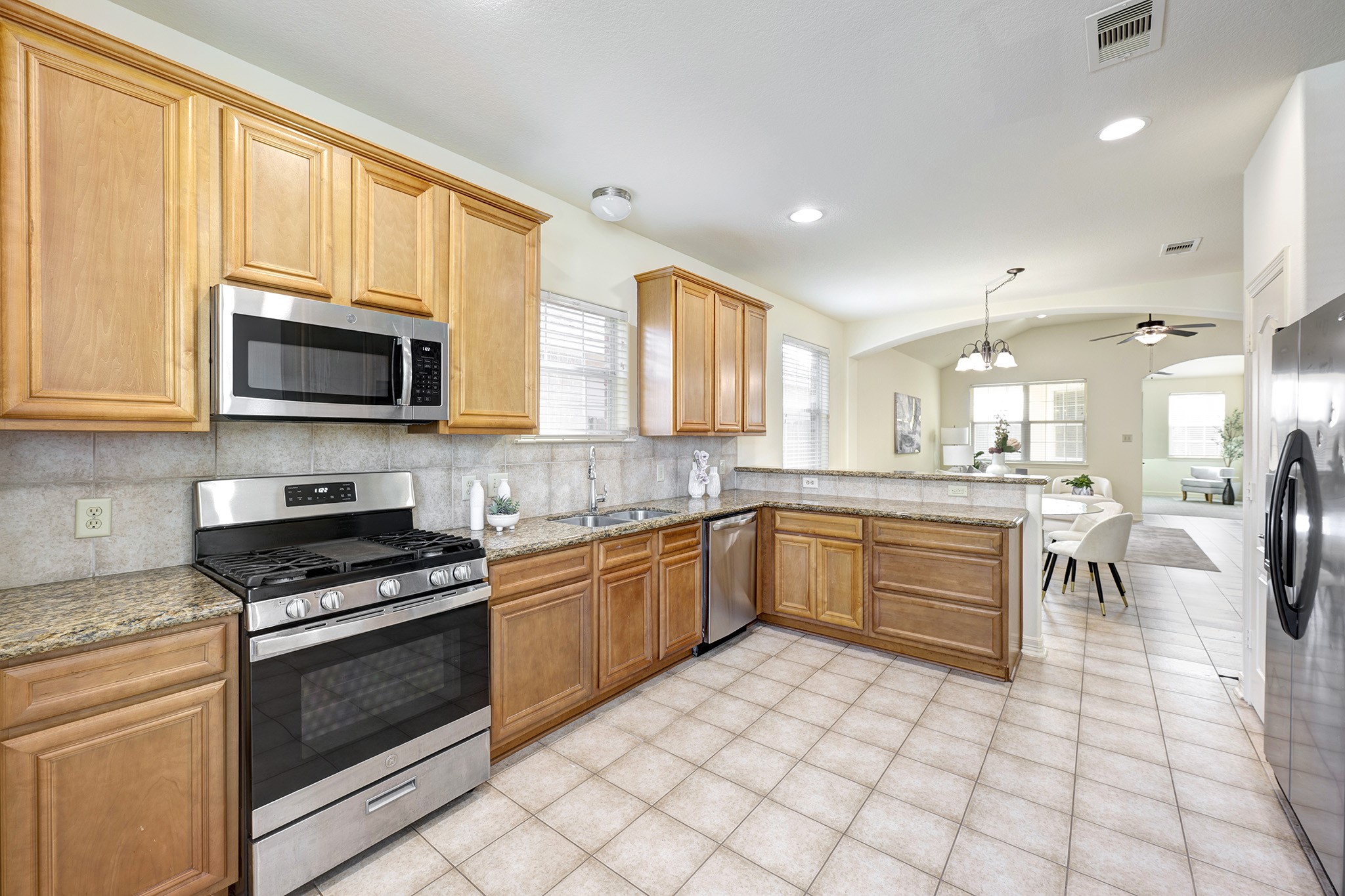 10348 Stone Gate Drive Conroe, TX 77385 - Photo 7 of 20 a kitchen with stainless steel appliances granite countertop a stove a sink and a microwave