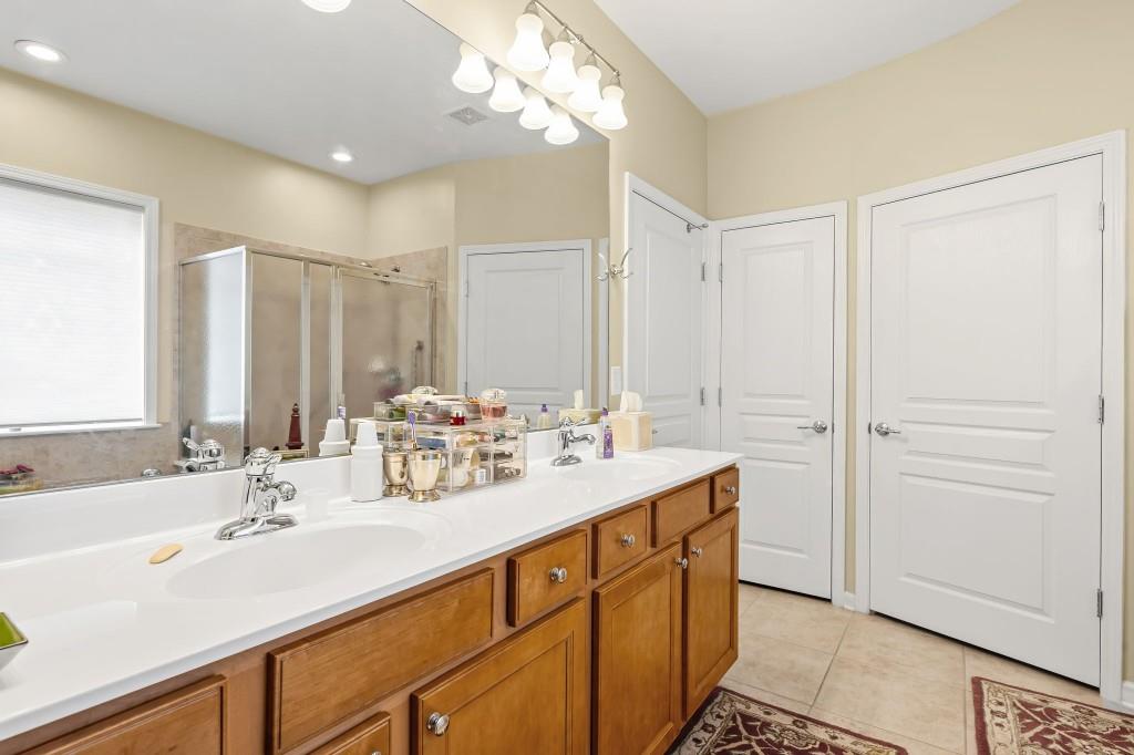 1081 Spring Station Road Greensboro, GA 30642 - Photo 21 of 35 a bathroom with a double vanity sink a mirror and a shower