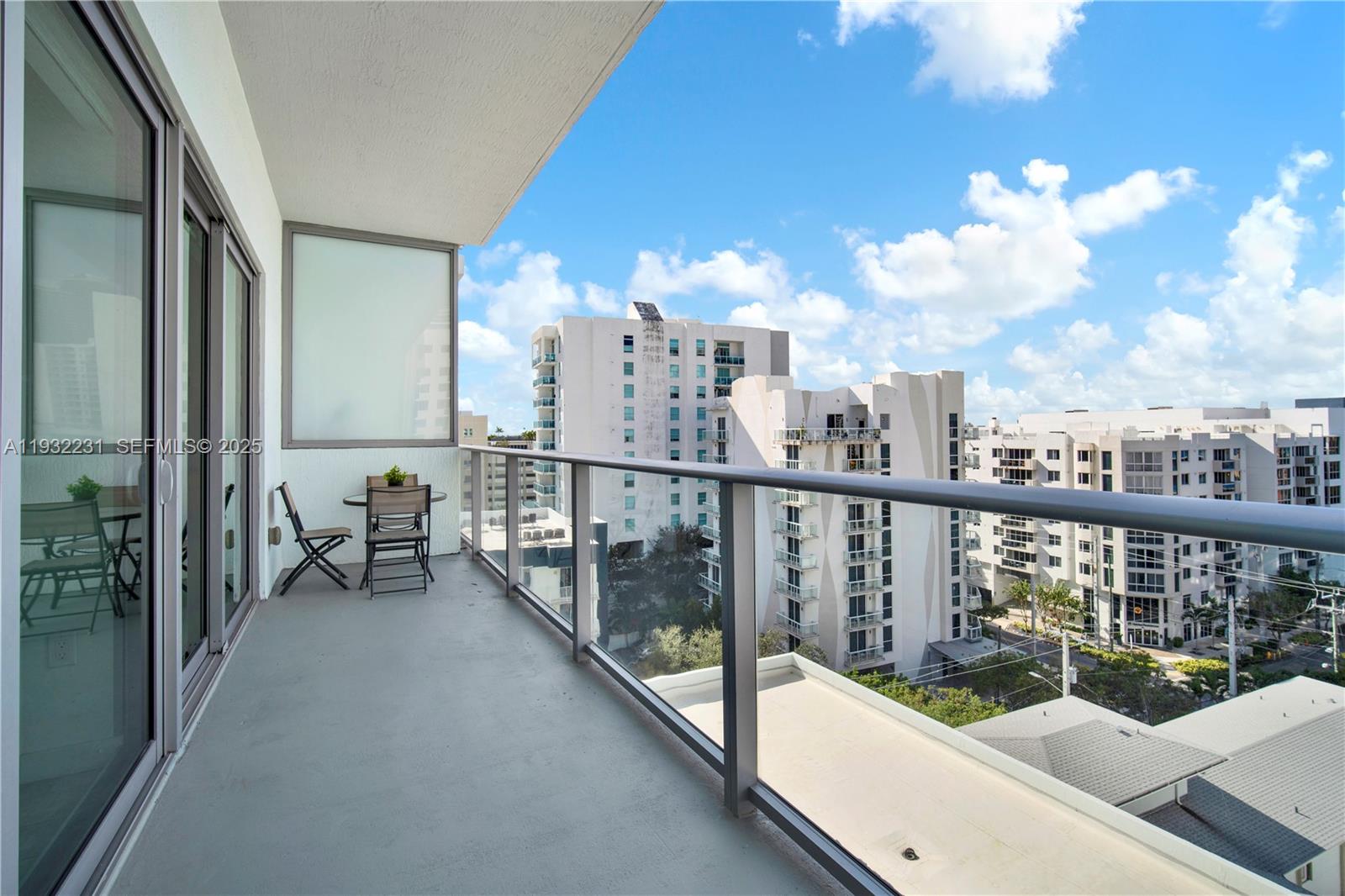 1600 Southwest 1st Avenue, Unit 804 Miami, FL 33129 - Photo 7 of 31 a view of a balcony with wooden chairs