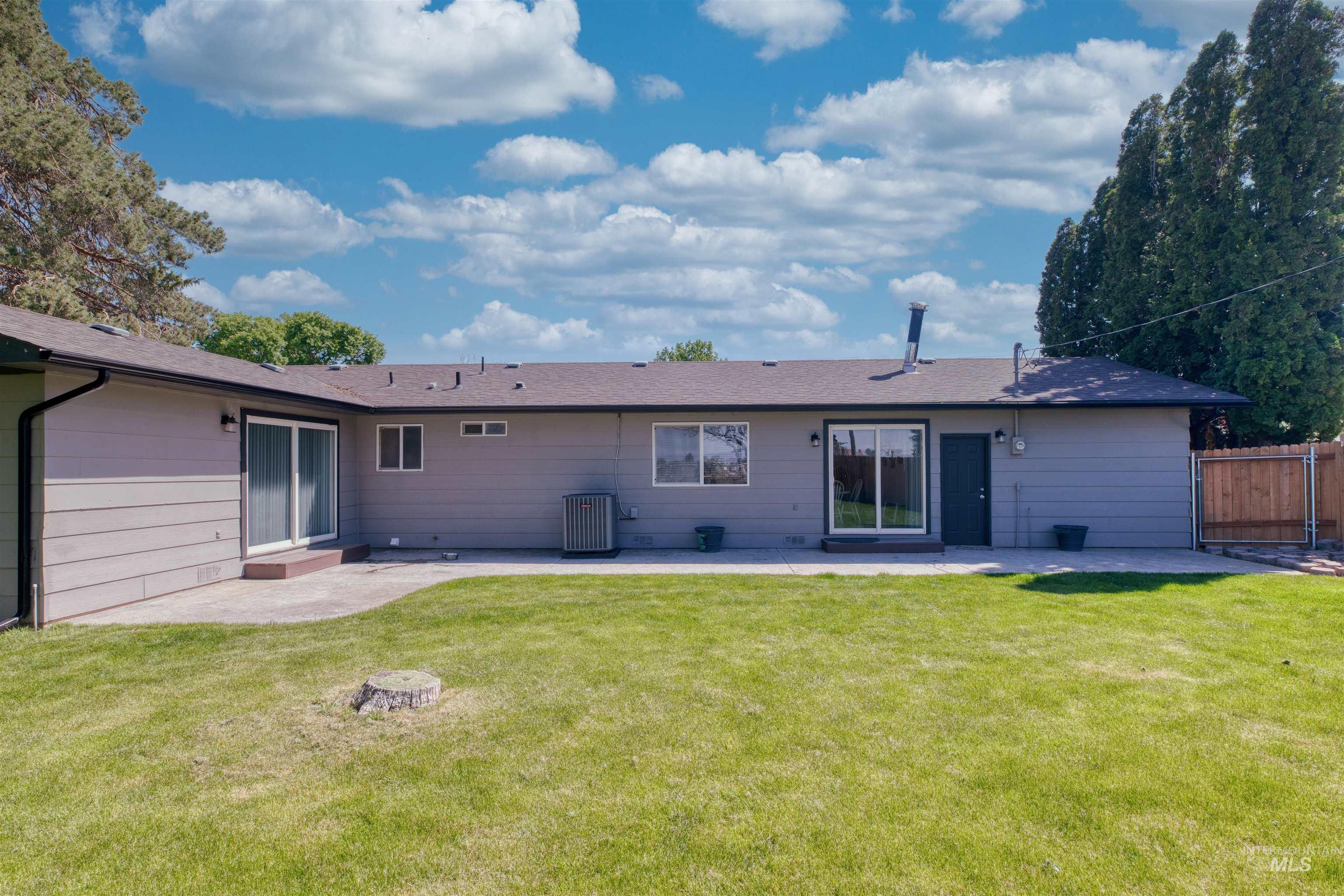 20803 Friends Road Greenleaf, ID 83626 - Photo 24 of 39 Rear exterior featuring grey horizontal siding, a private patio, two sets of sliding glass doors, and a wood privacy fence