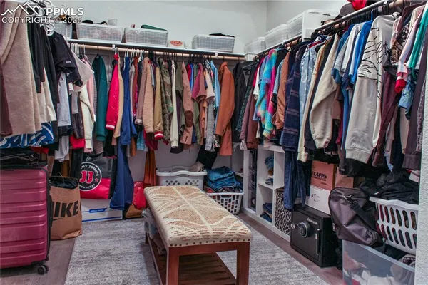 a view of walk in closet with clothes