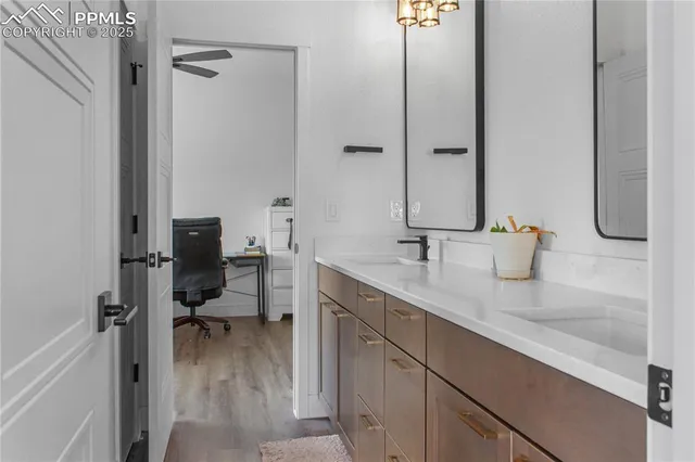 a en suite bathroom with a granite countertop sink and a mirror