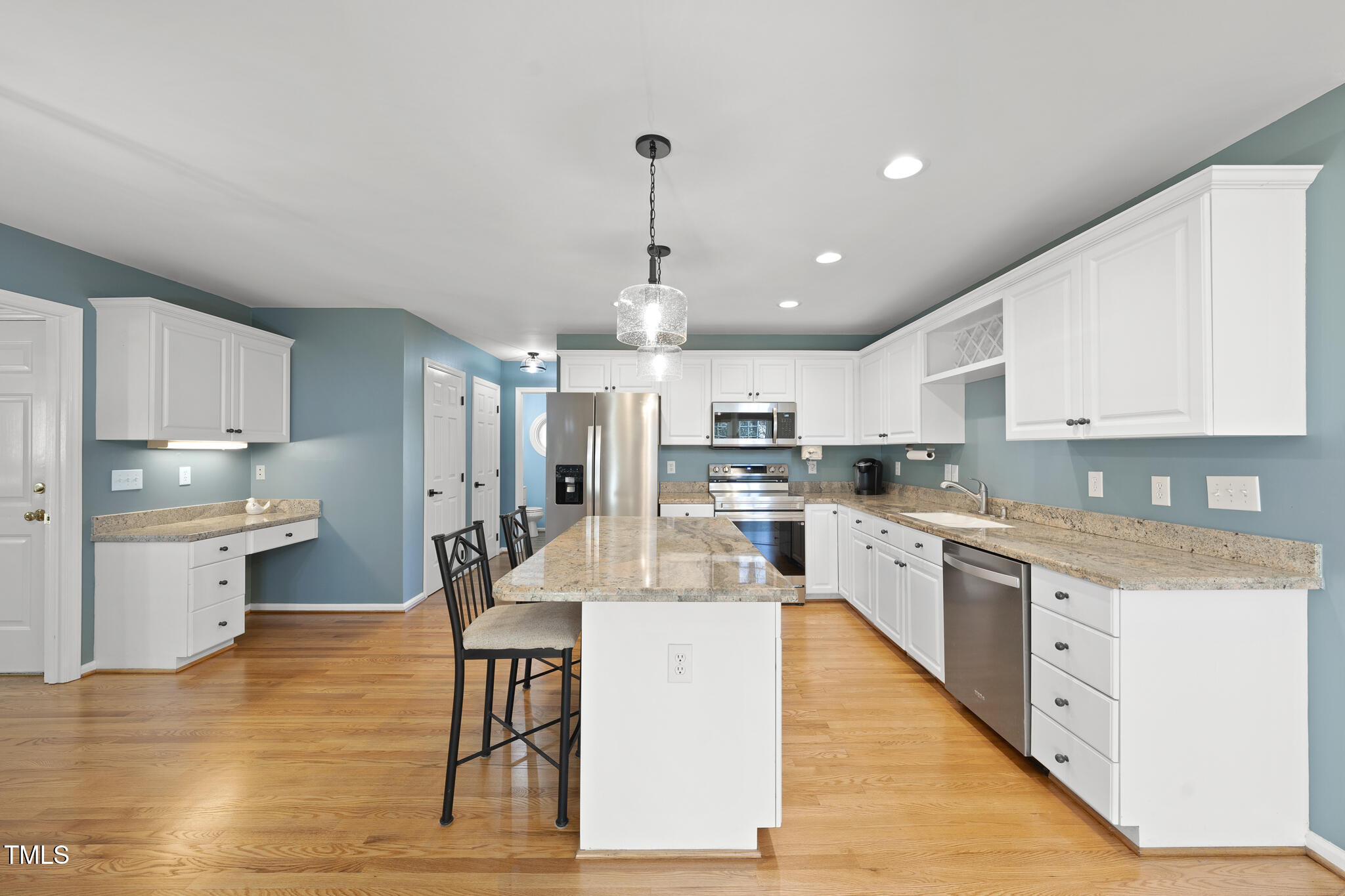 8063 Hogan Drive Wake Forest, NC 27587 - Photo 16 of 46 a large white kitchen with lots of counter space wooden floor and appliances