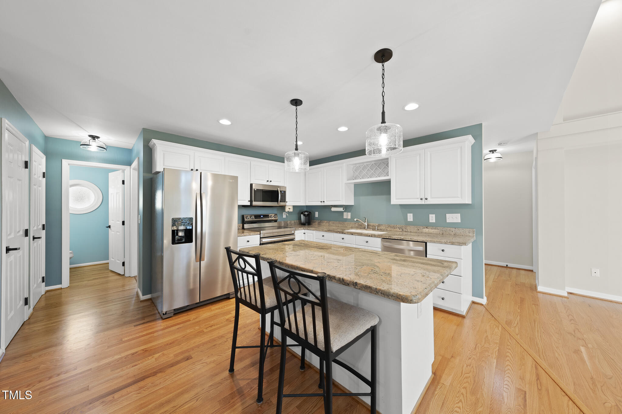 8063 Hogan Drive Wake Forest, NC 27587 - Photo 18 of 46 a kitchen with stainless steel appliances a dining table chairs stove and refrigerator