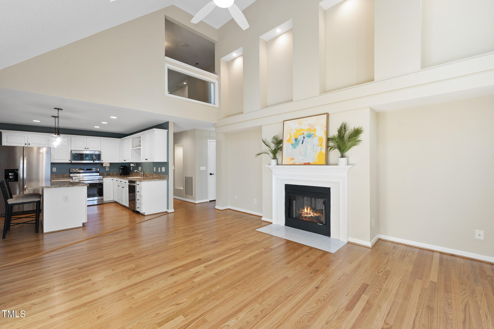 8063 Hogan Drive Wake Forest, NC 27587 - Photo 24 of 46 a view of kitchen livingroom with fireplace wooden floor and kitchen