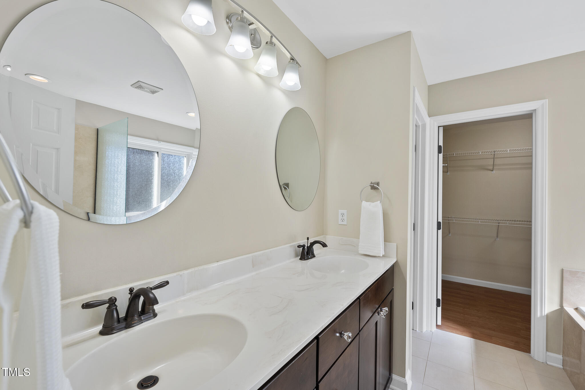 8063 Hogan Drive Wake Forest, NC 27587 - Photo 28 of 46 a bathroom with a double vanity sink and a mirror