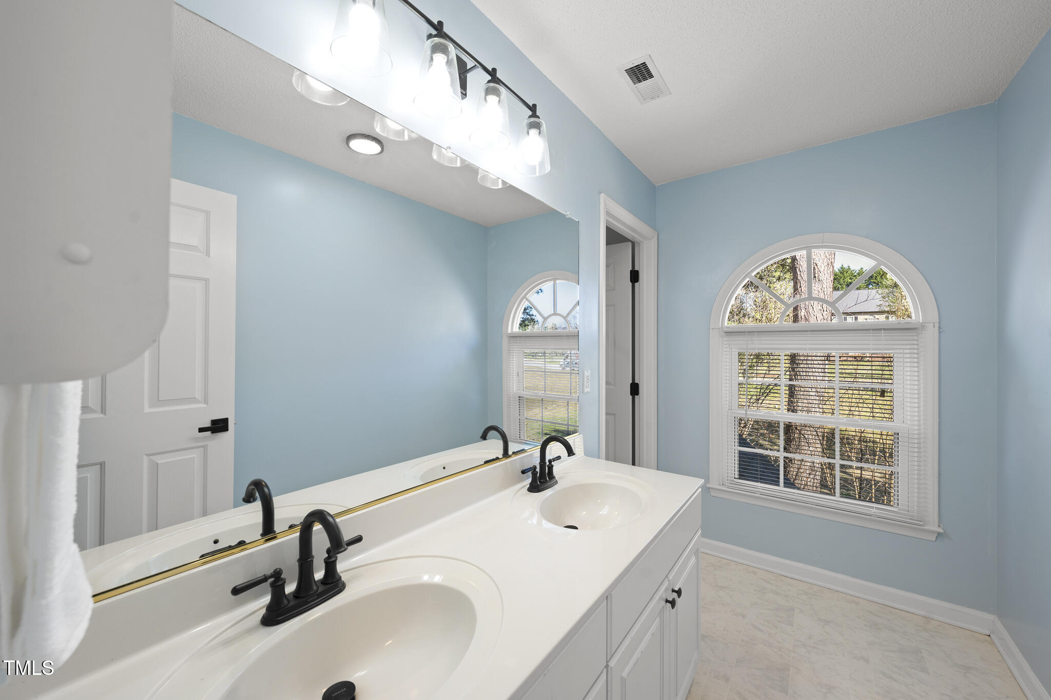 8063 Hogan Drive Wake Forest, NC 27587 - Photo 40 of 46 a spacious bathroom with a double vanity sink a mirror and a window
