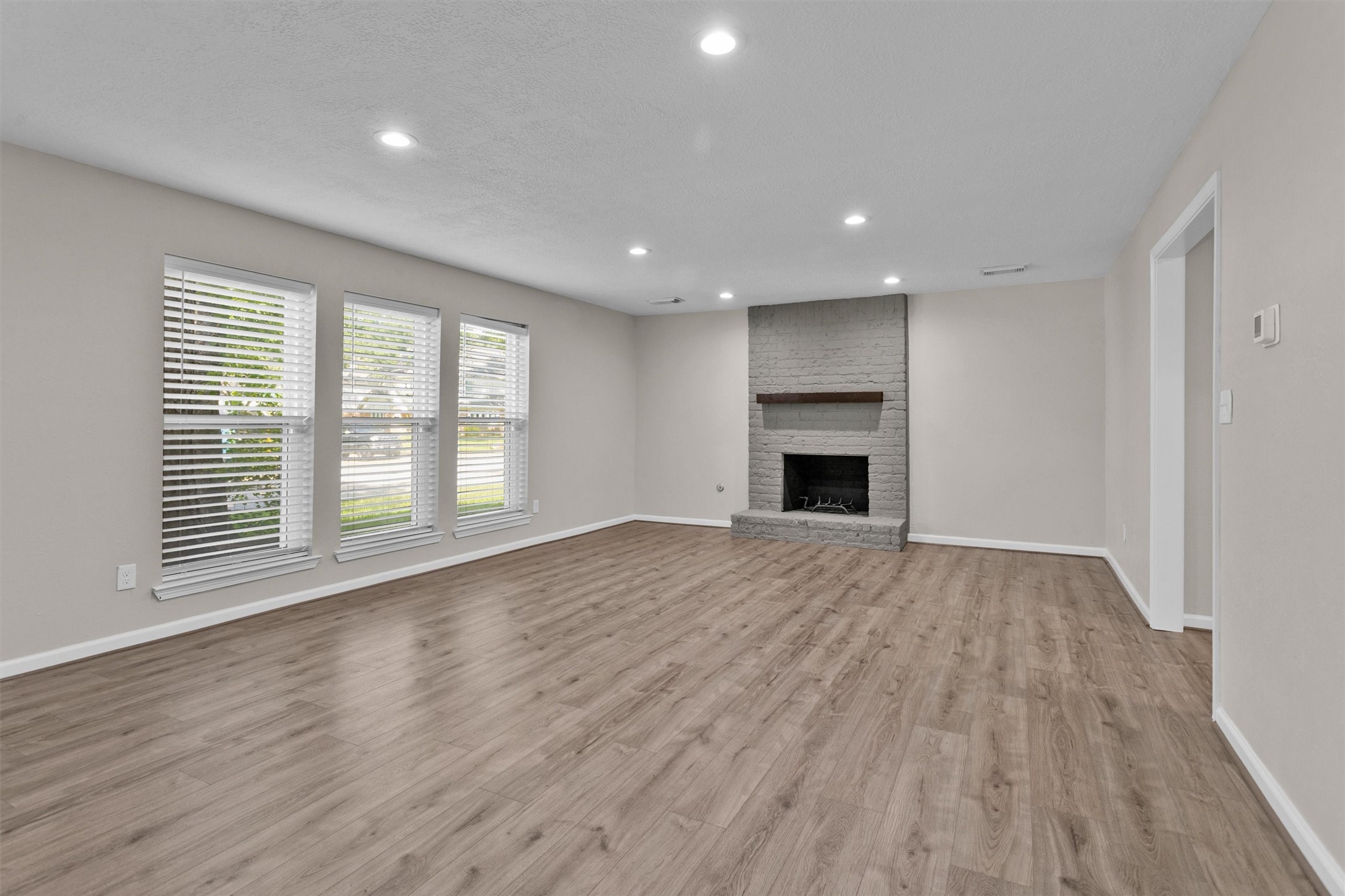 9115 Godstone Lane Spring, TX 77379 - Photo 6 of 46 This spacious living room features large windows for ample natural light, and a cozy fireplace, creating a warm and inviting atmosphere.