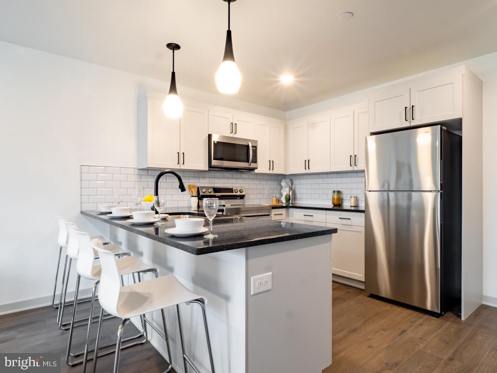 a kitchen with kitchen island a sink stove and refrigerator